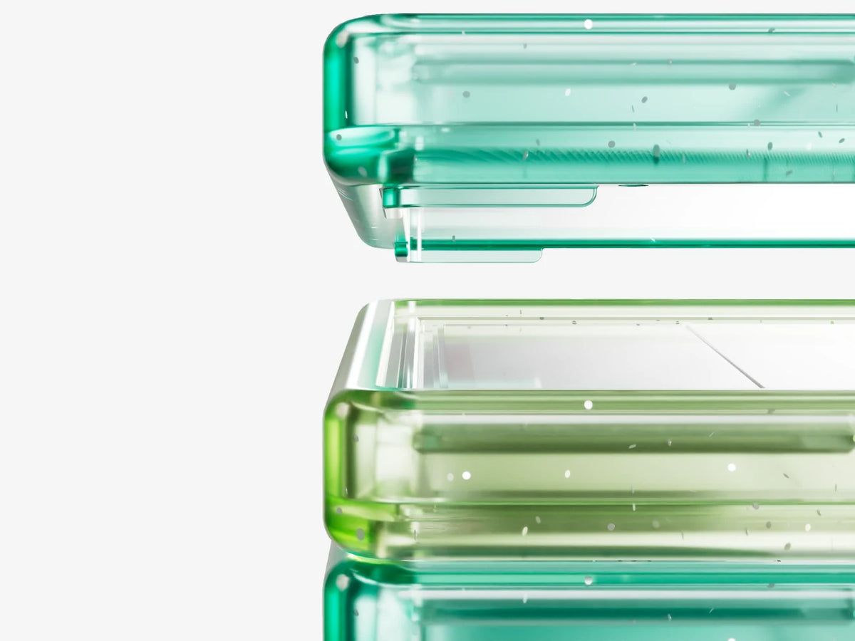 Close-up of stacked Bumpii Honeydew graded card guard frames showing translucent teal and lime corner details.
