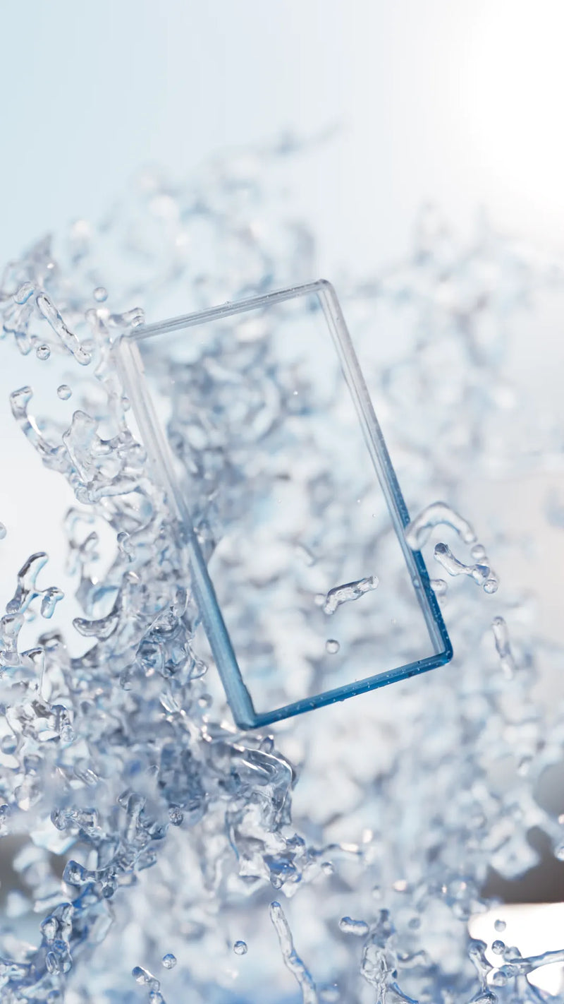 Bumpii Seasalt slab protector floating in a bright water scene, showing blue clear edges, PSA card fit and splash details.
